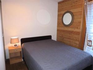 una camera da letto con un letto e uno specchio a parete di Résidence Bois De Marie - 4 Pièces pour 7 Personnes 564 a Barèges