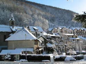 uma cidade com edifícios cobertos de neve e uma igreja em Résidence Bois De Marie - 4 Pièces pour 7 Personnes 564 em Barèges