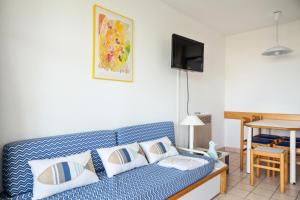 ein Wohnzimmer mit einer blauen Couch mit Kissen in der Unterkunft Résidence Port Bourgenay - maeva Home - Appartement 2 pièces 4 personnes - 20 in Talmont
