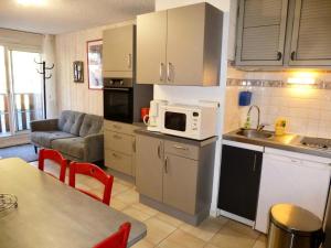 a kitchen with a couch and a microwave oven at Résidence Neouvielle - Appartement duplex dans le centre de Barèges MAE-8574 in Barèges