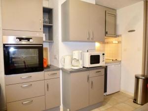 a kitchen with white cabinets and a microwave at Résidence Neouvielle - Appartement duplex dans le centre de Barèges MAE-8574 in Barèges
