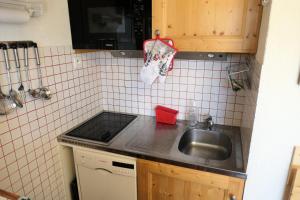 a kitchen with a sink and a tiled wall at Résidence Jaspe - 2 Pièces pour 6 Personnes 44 in Saint-Gervais-les-Bains