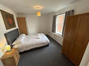 - une chambre avec un lit et une grande fenêtre dans l'établissement Spacious 2 Bed 2 Shower Apartment, à Crewe