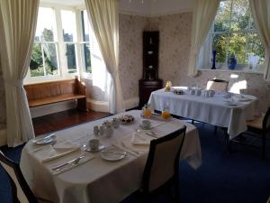 jadalnia z dwoma stołami z białymi obrusami w obiekcie Upper Letton Farm w mieście Leintwardine