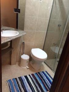 a bathroom with a shower and a toilet and a sink at Acosta Ñu Apart Hotel in Asunción