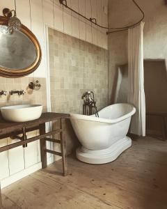 a bathroom with two sinks and a tub and a mirror at Domaine du tertre ychot in Dol-de-Bretagne