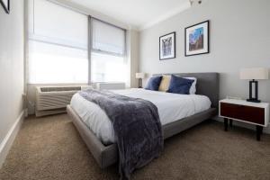 a bedroom with a large bed and a window at CozySuites 800 Tower 2BR w/sky pool, gym! 32 in Louisville