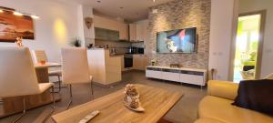 a living room with a table and a tv on a wall at Villa Kasandra in Kaštel