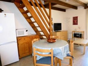a kitchen with a table and a white refrigerator at Résidence Neouvielle - Studio duplex avec place de parking dans le centre de Barèges MAE-8714 in Barèges