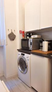 cocina con lavadora y microondas en Renovated Central Suites, en Florencia