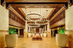 a lobby of a hotel with two chandeliers at Hyatt Regency Aruba Resort & Casino in Palm-Eagle Beach