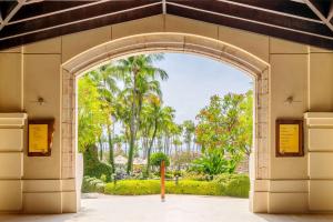 un accès voûté à un parc planté de palmiers dans l'établissement Hyatt Regency Aruba Resort & Casino, à Palm-Eagle Beach