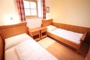 a room with two beds and a desk and a window at Ferienwohnung Königsleiten 37 - Top 1 in Königsleiten