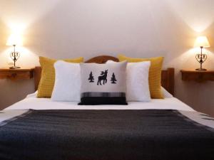 a bedroom with a bed with yellow and white pillows at Résidence Les Fermes Du Planet - Chalets pour 12 Personnes 74 in Valloire