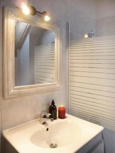 a bathroom sink with a candle and a mirror at Résidence Les Fermes Du Planet - Chalets pour 12 Personnes 74 in Valloire