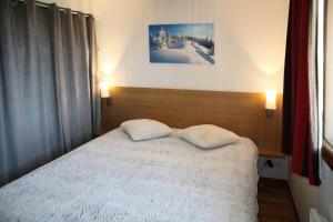 ein Schlafzimmer mit einem Bett mit zwei Kissen darauf in der Unterkunft LES CHALETS DE BOIS MEAN - 2 Pièces pour 6 Personnes 024 in Les Orres