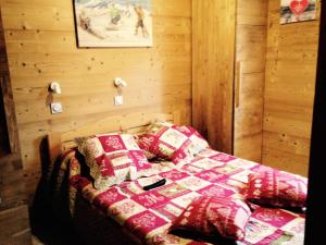 a bedroom with a bed with a quilt and pillows at Chalet Les Lupins - 4 Pièces pour 8 Personnes 14 in Valloire