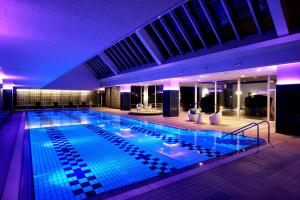 una gran piscina en un edificio con iluminación púrpura en Miyako Hotel Gifu Nagaragawa, en Gifu