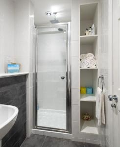 een douche met een glazen deur in de badkamer bij The Mount Holiday Home in Portinscale