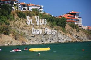 a group of boats in the water near a hill with graffiti at Marina Apartments St. Vlas in Sveti Vlas