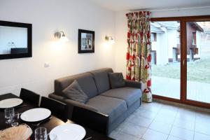 een woonkamer met een bank en 2 tafels bij Chalet La Combe D Or - Chalets pour 6 Personnes 094 in Le Mélézet