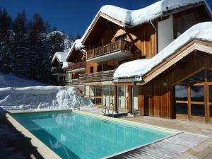 une maison avec une piscine dans la neige dans l'établissement Chalet La Combe D Or - Chalet mitoyen en résidence de standing MAE-2094, à Le Mélézet 11 autres photos