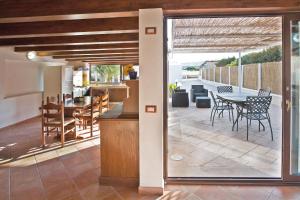 eine Küche und ein Esszimmer mit einer Terrasse mit einem Tisch in der Unterkunft Dune Giardino - Happy Rentals in Scicli