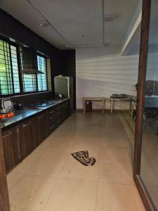 une grande cuisine avec des placards en bois et une table dans l'établissement Patil's Greenwoods FarmHouse, à Navi Mumbai