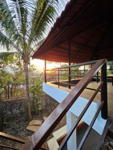 uma casa com uma palmeira e um alpendre em Patil's Greenwoods FarmHouse em Navi Mumbai