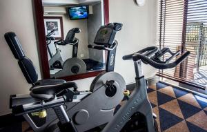 un gimnasio con cinta de correr y espejo en Garden Court East London en East London