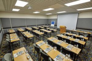 a classroom filled with tables and chairs and a whiteboard at Garden Court Mthatha in Mthatha
