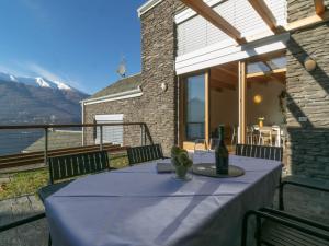 uma mesa com uma toalha de mesa azul numa varanda em Mamma Ciccia - breathtaking views with pool area em Bellano