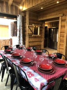 a table with red plates and wine glasses on it at Chalet Colenfrey - Chalets pour 10 Personnes 14 in Valloire