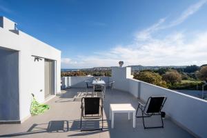 a balcony with chairs and a table on the roof at E&A luxury apartment with sea view in Rhodes Town