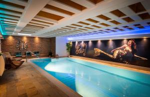 a large swimming pool with a large painting on the wall at Arthotel ANA Gold in Augsburg