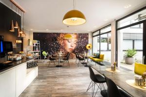 a living room with a large painting of a woman at Arthotel ANA Gold in Augsburg