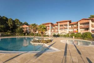 a resort with a swimming pool in front of a building at Résidence Le Domaine de Gascogne - maeva Home - Appartement 2 pièces 5 personnes Confort MAE-4457 in Biscarrosse +7 photos