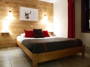 a bedroom with a bed with a wooden wall at Résidence Les Fermes Du Planet - Pièces 74 in Valloire