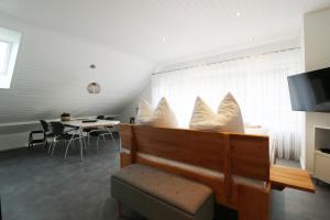 uma sala de estar com uma mesa e almofadas brancas em Ferienwohnung "Hygge" in Schluchsee em Schluchsee
