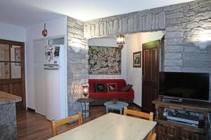 een woonkamer met een rode bank en een stenen muur bij Résidence Les Carlines - 2 Pièces pour 6 Personnes 011 in Les Orres
