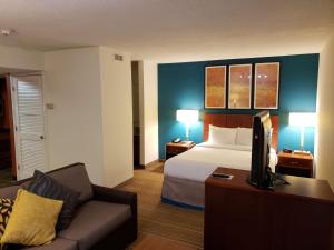 a hotel room with a bed and a couch at Tysons Corner Suites, A Baymont by Wyndham in Vienna