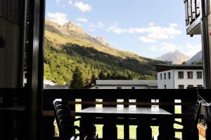 a table on a balcony with a view of mountains at Résidence Pre Malin - 2 Pièces pour 4 Personnes 84 in Valloire