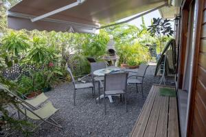 een patio met een tafel, stoelen en planten bij Chalet de 2 chambres a Vieux Habitants a 300 m de la plage avec terrasse et wifi in Vieux-Habitants