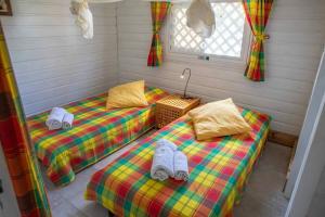twee bedden met handdoeken in een kamer bij Chalet de 2 chambres a Vieux Habitants a 300 m de la plage avec terrasse et wifi in Vieux-Habitants