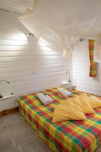 een slaapkamer met een bed met 2 kussens erop bij Chalet de 2 chambres a Vieux Habitants a 300 m de la plage avec terrasse et wifi in Vieux-Habitants