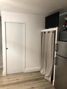 een witte kamer met een deur en een koelkast bij Résidence Antigua - Studio pour 4 Personnes 984 in Le Barcarès