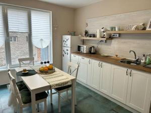 a kitchen with a table and a white refrigerator at NiDo Cozy 3BR Apartment Kapana Top Center in Plovdiv