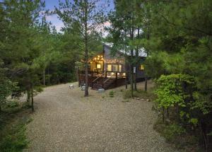a cabin in the woods with a gravel driveway at BRAND NEW!! Hochatown, Honey! Fire pit, hot tub, luxurious shower! in Broken Bow