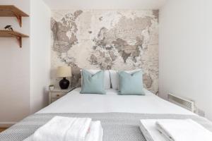 a bedroom with a large white bed with blue pillows at The East Dulwich Collection in London