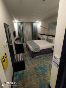 Habitación de hotel con cama y escritorio en فندق اوبن هوتيل مكه المكرمه en La Meca